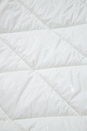 Close-up of a white quilted comforter with diamond pattern
