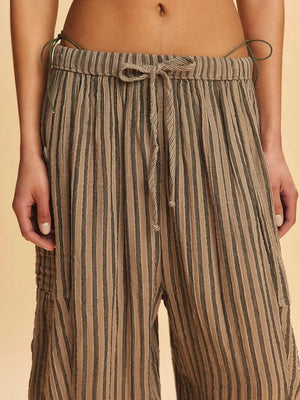 Striped pants with a drawstring waist on a beige background