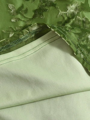 Close-up of green fabric with floral embroidery