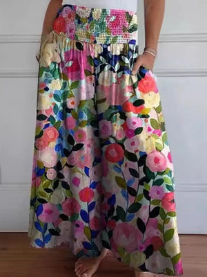 Colorful floral skirt worn by a person against a white wall.