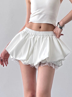 White skirt with lace trim worn by a person on a gray background