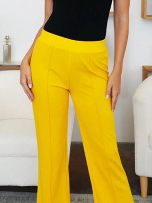 Person wearing yellow pants and a black top in an indoor setting