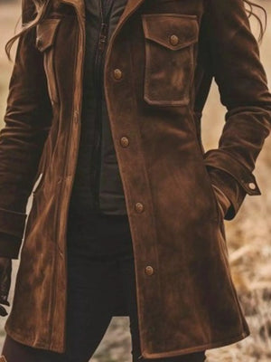 Brown leather coat with buttons and pockets on a blurred natural background