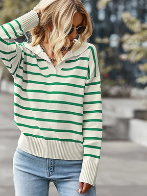 Person wearing a green and white striped sweater with a blurred outdoor background