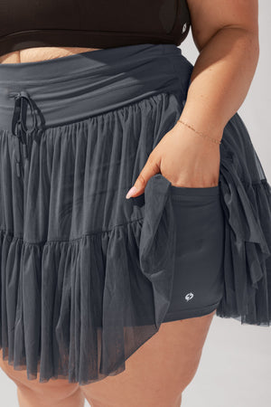 Person wearing a layered skirt with a plain background