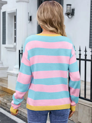Person wearing a colorful striped sweater in front of a building.