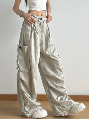 Person wearing beige wide-leg pants with a plain background