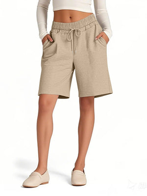 Person wearing beige shorts on a white background