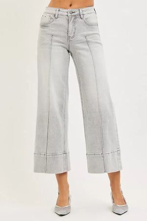 Light gray wide-leg jeans worn by a person on a white background