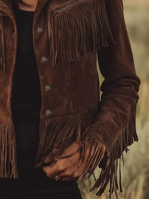 Brown suede jacket with fringes on a blurred natural background