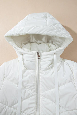White quilted jacket with a hood on a beige background