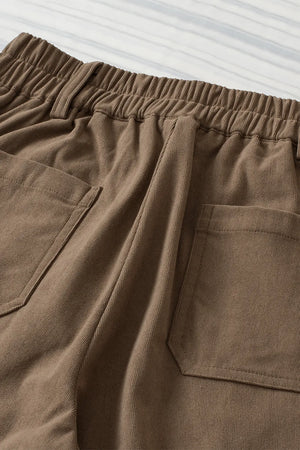 Close-up of brown pants with pockets on a light gray background