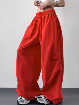 Red wide-leg pants worn by a person on a plain background