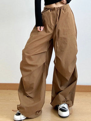Person wearing brown wide-leg pants on a plain background