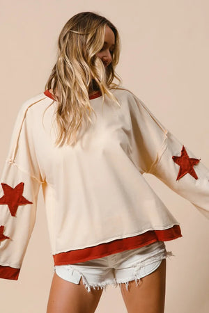 Woman wearing a white top with red star designs on a beige background