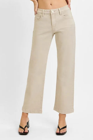 Beige wide-leg jeans worn by a person on a white background