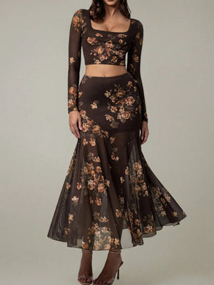 Dark floral dress with sheer sleeves on a neutral background