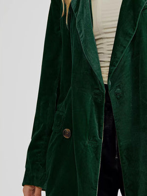 Green coat worn by a person on a light gray background