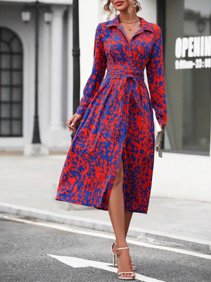 Woman wearing a red and blue patterned dress on a city street.