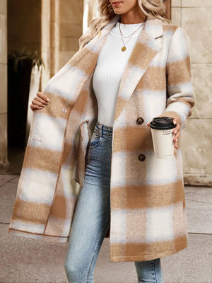 Person wearing a plaid coat holding a coffee cup on a city street.