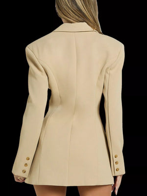Beige blazer worn by a person on a black background