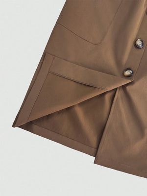Close-up of a brown garment with buttons on a light gray background