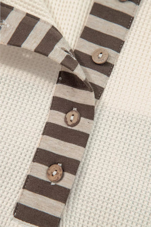 Close-up of a striped fabric with buttons on a textured beige background