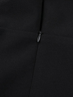 Close-up of a black coat with a zipper detail on a dark background
