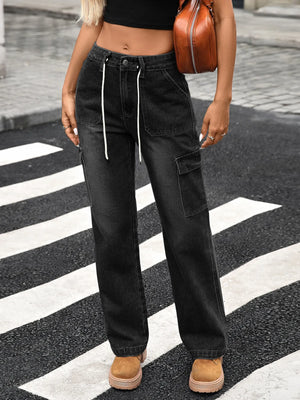 Person wearing black cargo pants on a street with a crosswalk.