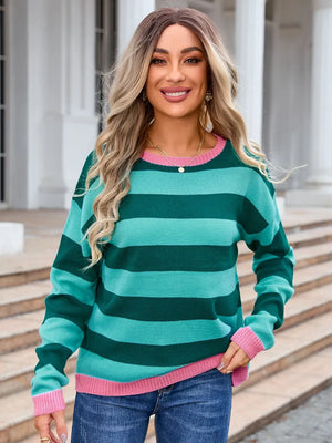Woman wearing a green and pink striped sweater with a blurred background
