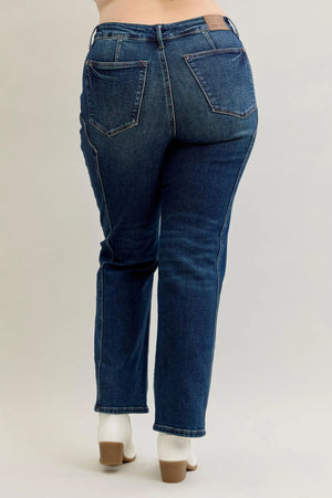 Blue jeans worn by a person on a plain background