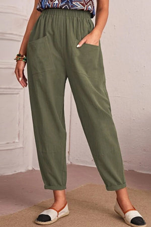 Person wearing green pants with a plain background