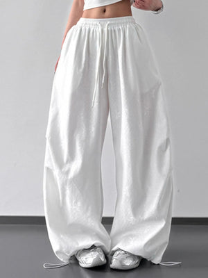 White wide-leg pants worn by a person on a plain background