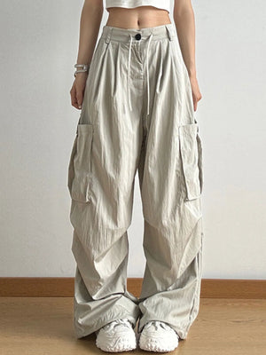 Person wearing beige cargo pants with a white background