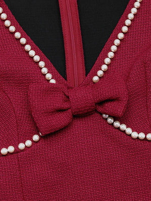 Red garment with a bow and pearl trim on a black background