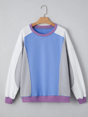 Color-blocked sweatshirt with purple, blue, and white sections on a gray background