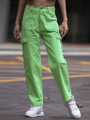 Person wearing bright green cargo pants on a blurred street background
