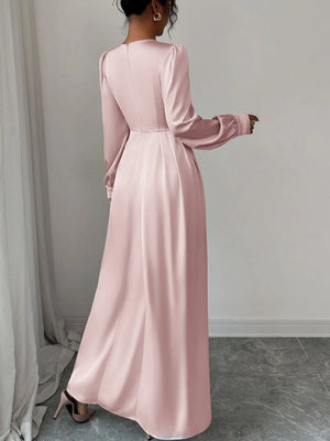 Woman wearing a pink long-sleeve dress against a plain background