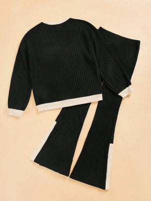 Black ribbed knit outfit with white trim on a beige background