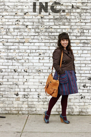 Model standing by a wall showing full view of Mi Vida Foldover Tote