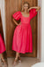 Model leaning on wall showing Cherie Puff Sleeve Midi dress- red