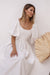 Woman sitting showing a view of Cherie Puff Sleeve Midi dress- white