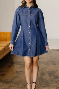 Woman wearing a blue denim dress in an indoor setting