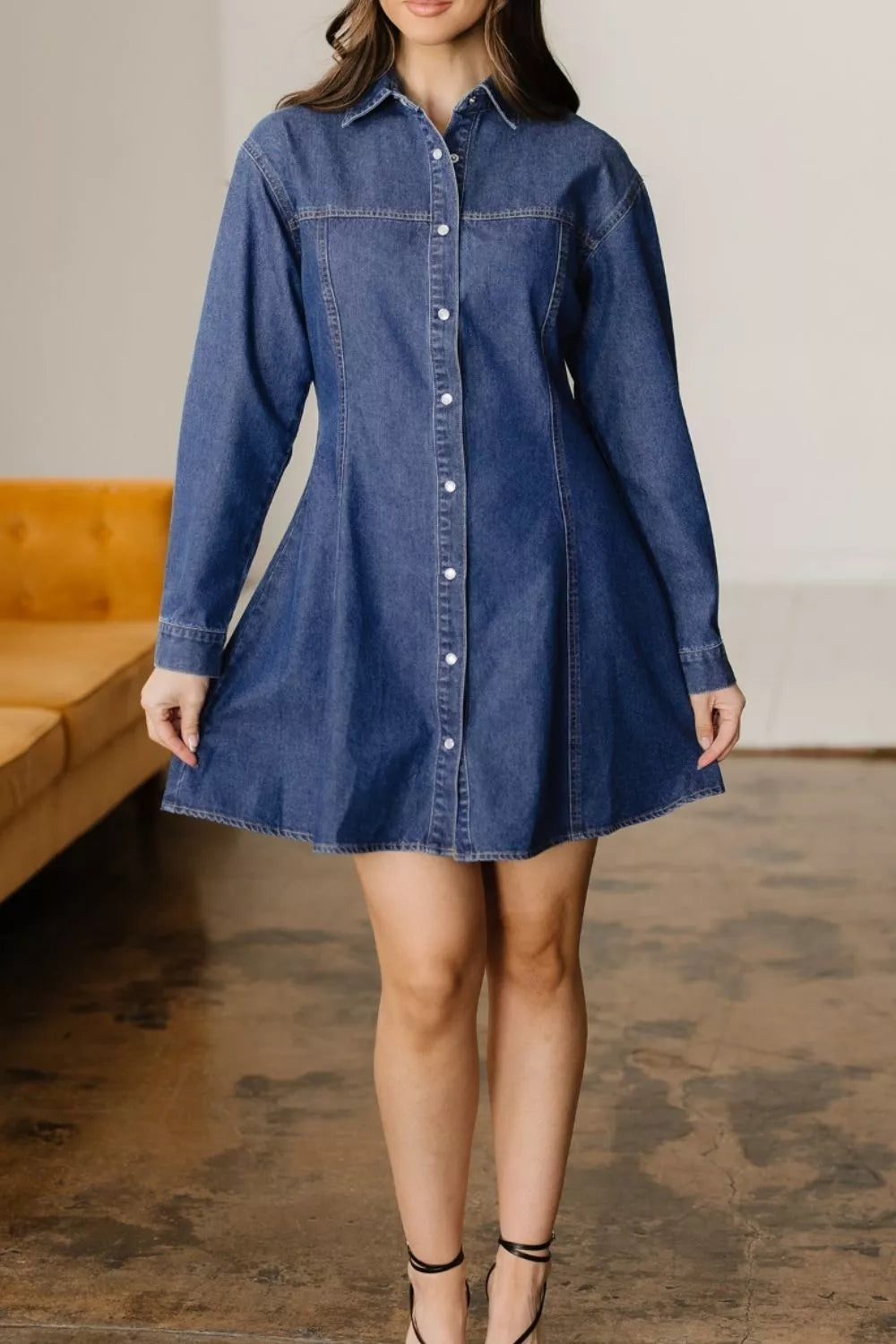 Woman wearing a blue denim dress in an indoor setting