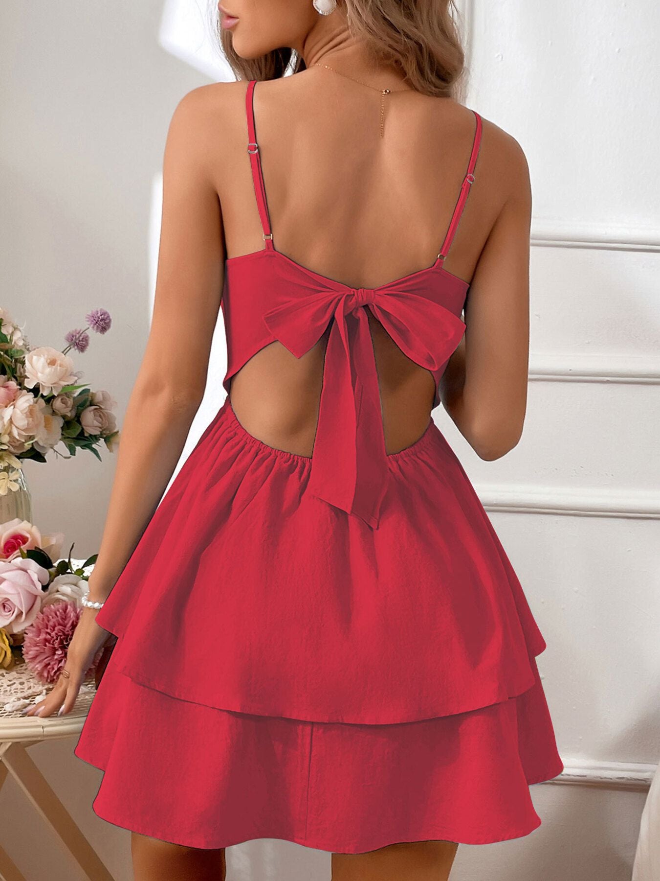 Red dress with open back and bow detail on a neutral background