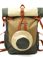 Backpack with roll-top design and circular front pocket on a white background