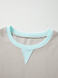 Close-up of a gray garment with a light blue neckline on a light gray background