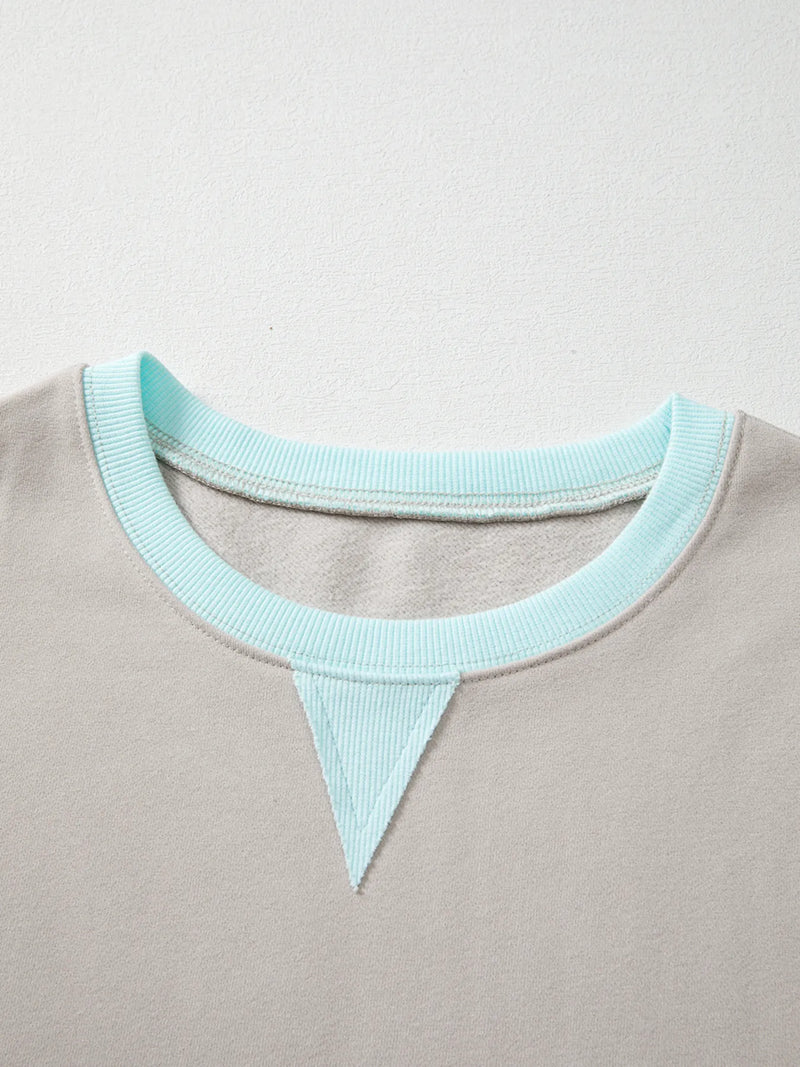 Close-up of a gray garment with a light blue neckline on a light gray background