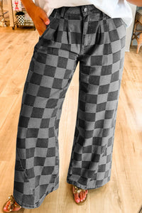 Person wearing checkered pants on a wooden floor