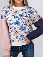 Floral patterned sweater with pink and purple sleeves on a plain background